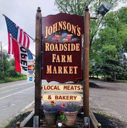 Johnson's Roadside Farm Market sign with American flag.