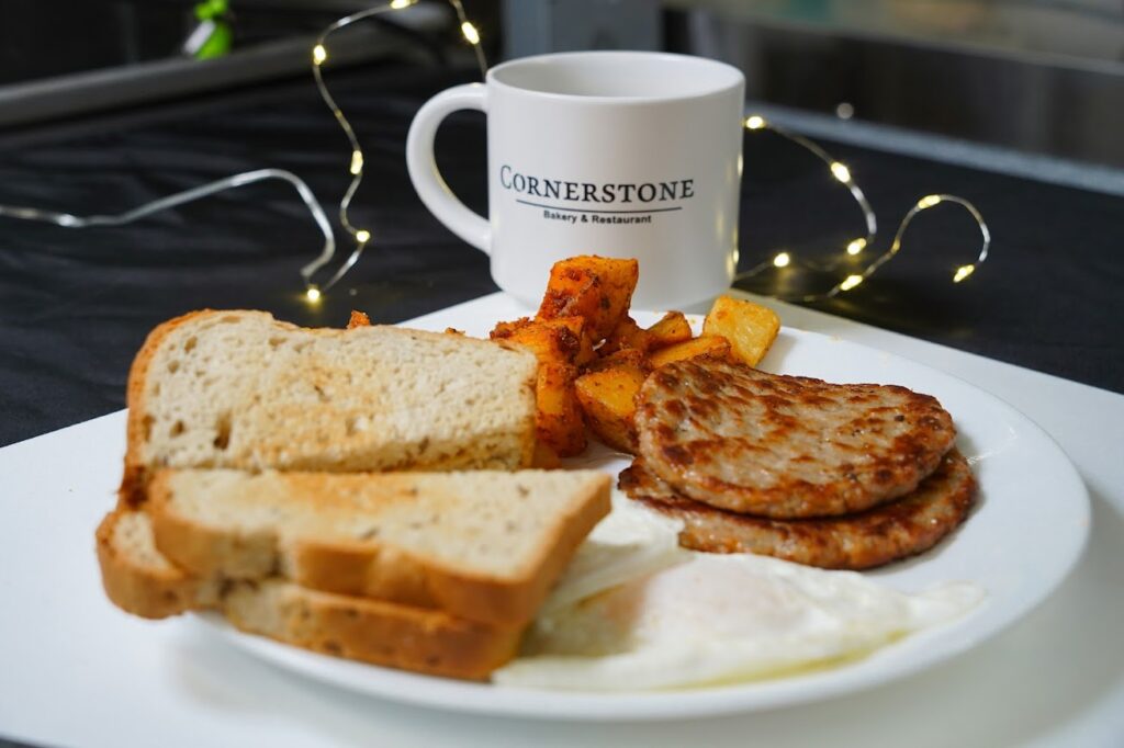 Breakfast plate with eggs, sausage, toast, and coffee